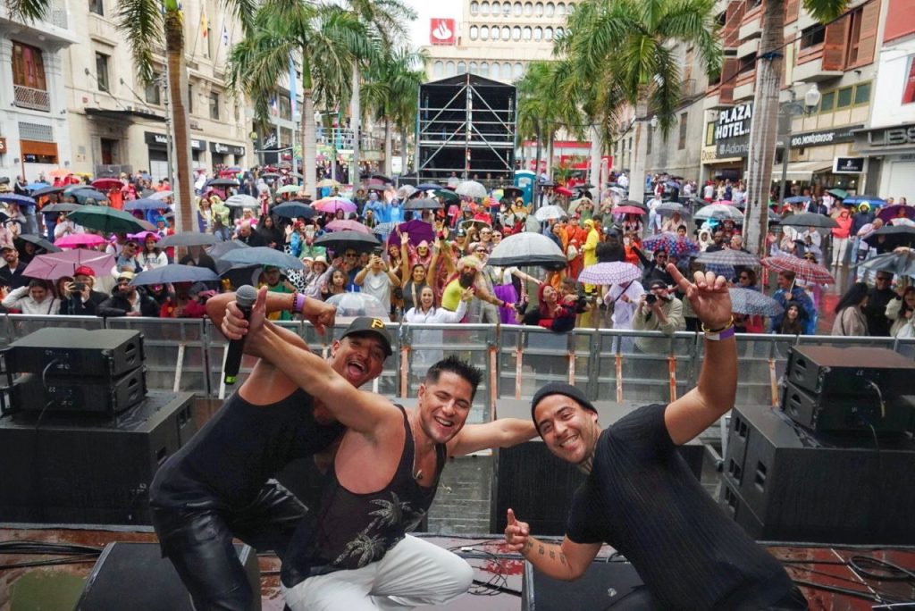 Orquesta actuando frente al público, con paraguas.